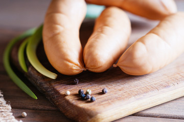 Raw sausages on wooden cutting board 