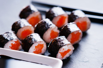 Sushi rolls with salmon, chopsticks and soy sauce 