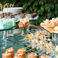 Appetizers, finger food, party food, sliders. Canape, tapas. Served table at summer terrace cafe. Catering service. Outdoor restaurant table with food.