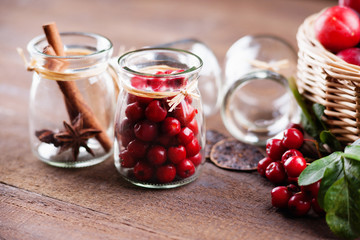Glass jars, plums in a basket and rowanberry