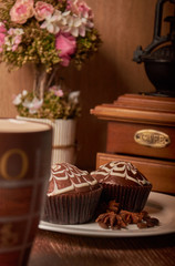 Chocolate muffins on a white plate with a cup