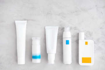Skincare cosmetic products from above on white marble table. Cream, cleancer, bb, cc foundation, sunscreen, moisturizer, lotion. Branding mock up. Copyspace