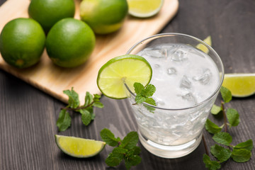 Fresh cocktail with lime, ice and mint on a rustic background. Copy space, top view