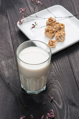 Dairy products. A glass of milk serve with almond candies on a rustic wooden table.