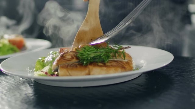 Close-up Serving Fish on a Plate Decorated with Vegetables and Salat