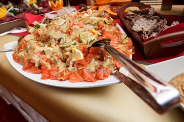 Fresh salmon salad served on a wide plate on a table