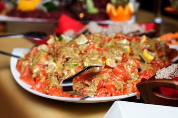 Fresh salmon salad served on a wide plate on a table