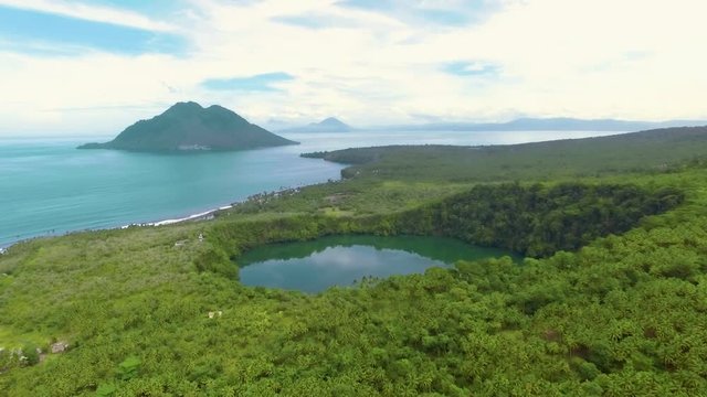Aerial view of tropical Lake Tolire and volcano island in Ternate, Indonesia. Shot with drone on cloudy day