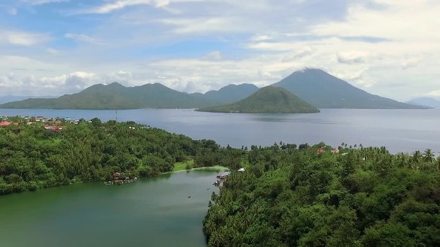 Aerial view of tropical Laguna Lake Tidore and volcano island in Ternate, Indonesia. Shot with drone on sunny day with blue sky in Indonesia, fly forward