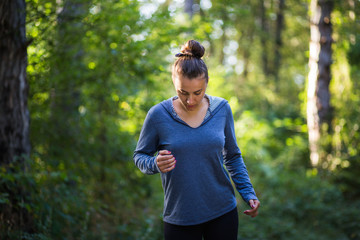 Young female model jogging in the woods