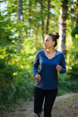 Young female model jogging in the woods