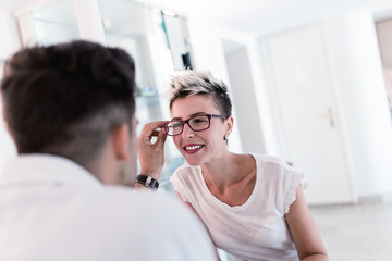 Male optometrist checking patient's vision at eye clinic.
