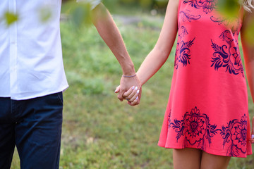 A guy with a girl holding hands in the Park.