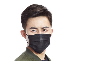 asian man wearing black mask looking at camera, isolated on white background. 