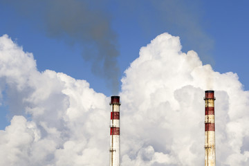 Industrial chimney against cloudy sky