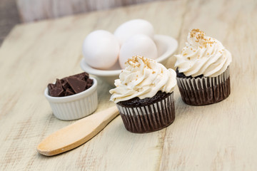 Chocolate Cupcakes With Vanilla Icing and Eggs