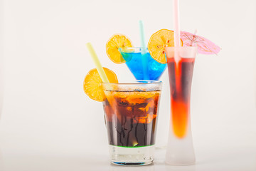 Colorful cocktail decorated with fruit, colorful umbrella, ice cubes, party night