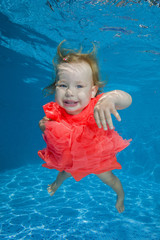 Fototapeta na wymiar little girl learns to swim underwater in the pool