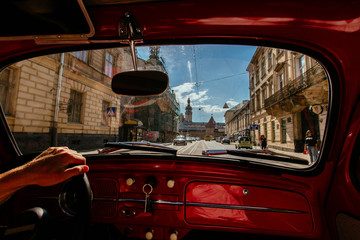 View of the road of old city street through the windshield of the retro car.