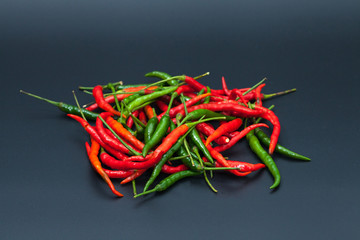red and green chilli hot pepper on black background