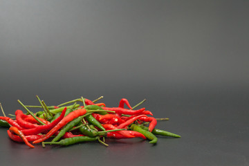 red and green chilli hot pepper on black background