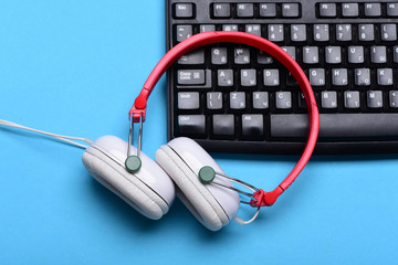 Electronic appliances on turquoise background. Headphones and black keyboard