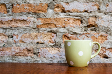 Green coffee mug on wooden floor