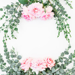 Floral frame with pink roses and eucalyptus branches on white background. Flat lay, top view