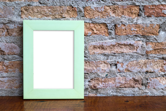 Green picture frame on wooden floor