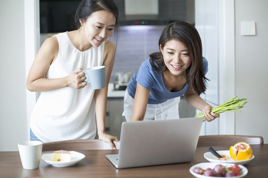 Best female friends using laptop for online recipe