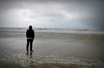 Mann bei Regen am Meer