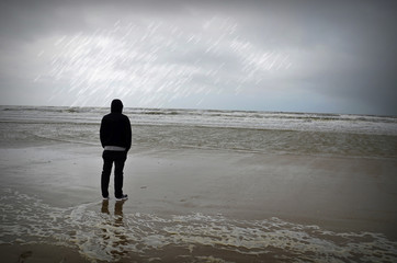 Mann bei Regen am Meer, Strand Lakolk, Nordseeinsel Rømø