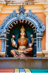 Fototapeta premium Statue Hindu deities on the roof of temple within Batu Caves. Batu Caves - a complex of limestone caves in Kuala Lumpur, Malesia