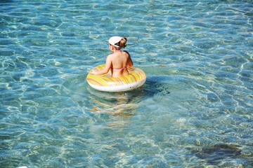 Cute girl in transparent water swimming, unrecognizable person in water, in Tyrrhenian sea, in Elba...