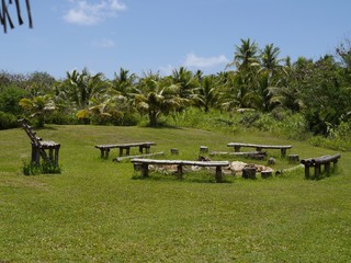 Outdoor bonfire place with wooden and bamboo benches in a circle in the middle of a garden