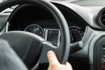 Man driving a car with his hands on the steering wheel