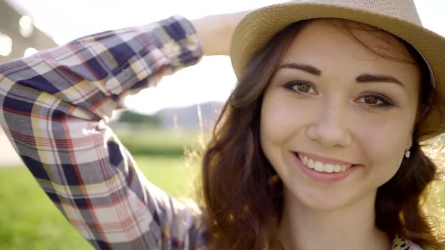 Happy smiling black woman holding hat city street. Fashionable girl