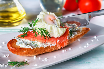 sandwich with ricotta cheese, salmon and poached egg on a plate