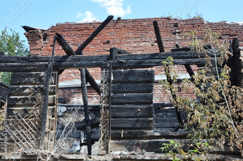 Charry Wooden Framework Of A Burnt House Against A Red Brick Wall