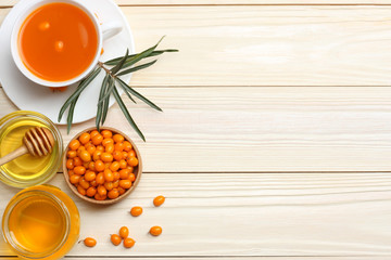 Sea buckthorn in wooden bowl, honey, Sea buckthorn juice on wooden table. top view with copy space