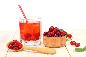 dogwood berries in wooden bowl with dogwood juice on white wooden table