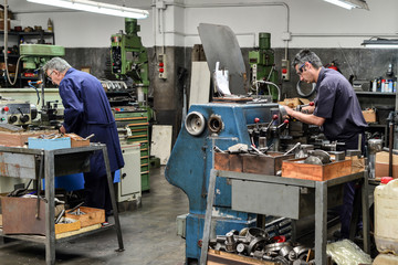Two men working in a metal workshop