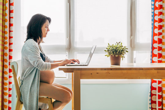Pregnant working with the computer in the living room