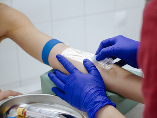 Nurse taking blood for analysis via veins projector device