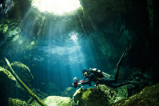 A scuba diver swimming in Mexico's Cenote Tajma Ha