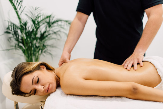 Woman enjoying back massage at spa