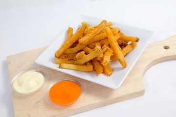 Hot and spicy french fries on a white plate with mayonnaise and cheese sauce