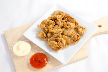 Fried crispy chicken breaded with corn flake crumbs with ketchup on wooden board.