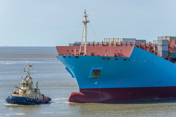 Containerschiff und Hafenschlepper