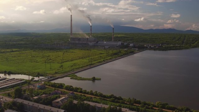 Aerial 4K: Pollution concept, Smoke or Steam from an Industrial Chimney, Thermal Power Plant with Huge Cooling Towers and Steam situated in the Ciity, Industry Scenery, Factory View 4k